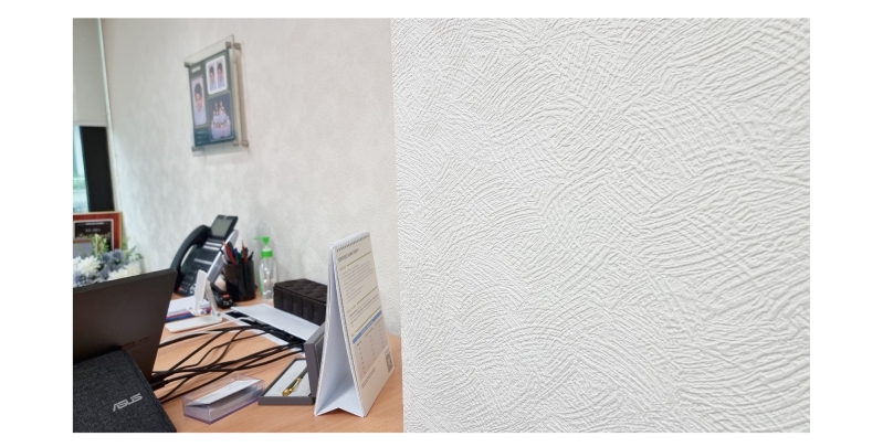 Textured white wallpaper and office desk with equipment